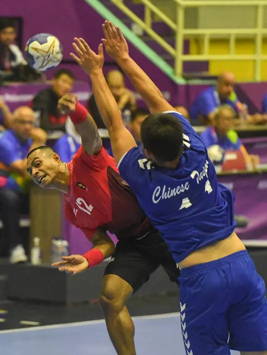 Pemain bola tangan putra Indonesia, Viktorius Rafael Tolang (12) dihadang pemain Chinese Taipei, Hsiumin Wu (11) dalam babak utama grup 3, Asian Games 2018 di GOR Popki, Cibubur, Jumat (24/8). Indonesia kalah 19-37 (ANTARA FOTO/INASGOC/Fulli Syafi/mes/18)