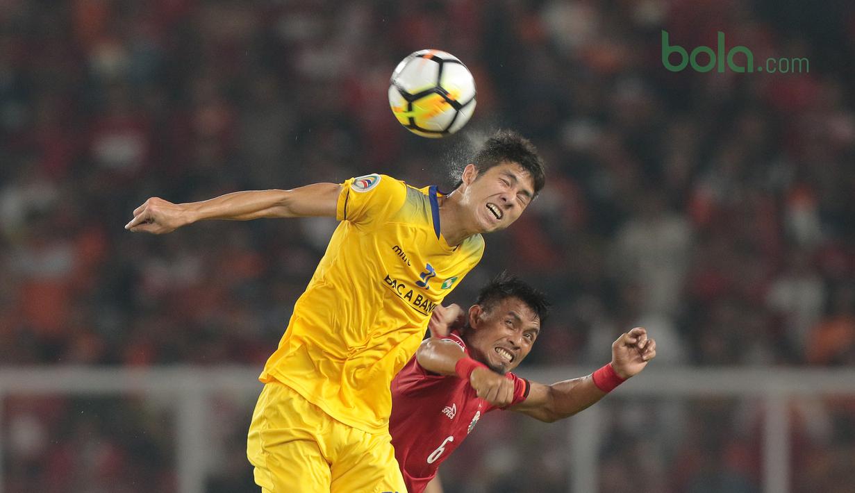 Duel pemain Persija Jakarta, Maman Abdurahman (kanan) dan pemain Song Lam Nghe An FC pada laga Piala AFC 2018 di Stadion Utama GBK, Senayan, Jakarta, (13/3/2018). Persija menang 1-0. (Bola.com/Nick Hanoatubun)