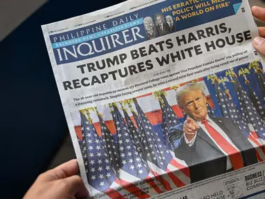 Sebuah foto menunjukkan halaman depan sebuah surat kabar di Manila, Filipina pada tanggal 7 November 2024 yang menunjukkan berita utama tentang terpilihnya kembali Donald Trump sebagai Presiden Amerika Serikat. (JAM STA ROSA/AFP)