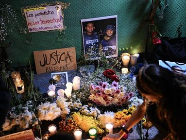 Seorang wanita meletakkan lilin di altar sebagai penghormatan bagi jurnalis yang tewas akibat serangan Israel di Jalur Gaza, saat menghadiri doa bersama di Mexico City pada 12 Agustus 2025. (Yuri CORTEZ/AFP)