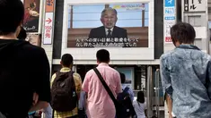 Warga menyaksikan video pidato Kaisar Akihito di Tokyo, Jepang, (8/8). Kaisar mengungkapkan keinginannya untuk turun tahta karena faktor kesehatan dan kekhawatiran dirinya tidak mampu melaksanakan tugas Kekaisaran secara penuh. (AFP PHOTO/Toru Yamanaka)