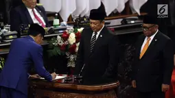 Presiden Joko Widodo menandatangani RUU tentang APBN TA 2020 beserta Nota Keuangan dan pendukungnya disaksikan Ketua DPR Bambang Soesatyo dan Ketua DPD Oesman Sapta Odang dalam Sidang Paripurna di Gedung DPR, Jakarta, Jumat (16/8/2019). (Liputan6.com/JohanTallo)