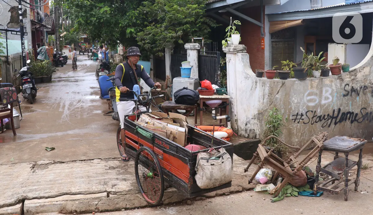 Pengumpul barang bekas berkeliling di Ciledug Indah, Tangerang, Banten, Senin (21/2./2021). Pasca banjir melanda perumahan tersebut menjadi berkah bagi para pengumpul barang rongsok karena banyak barang yang di buang pemilik rumah. (Liputan6.com/Angga Yuniar)