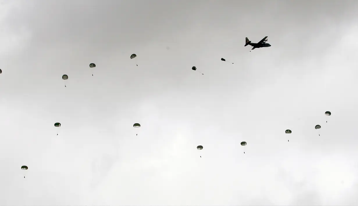 Tentara udara melompat dari pesawat kargo C-130 Hercules pada latihan tahunan Han Kuang di sebuah pangkalan udara di Taichung, Kamis (7/6). Latihan militer tahunan terbesar ini digelar di tengah kian agresifnya China terhadap Taiwan. (AP/Chiang Ying-ying)
