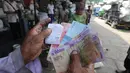 Pemulung menunjukkan uang hasil penjualan sampah plastik di pabrik pengolahan kawasan Kapuk, Cengkareng, Jakarta, Selasa (17/9/2019). Rata-rata sampah plastik yang diolah di tempat ini mencapai 1,5 ton per hari. (merdeka.com/Arie Basuki)