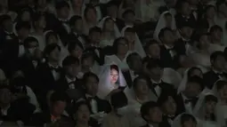 Pengantin wanita bermain smartphone-nya dalam upacara pernikahan massal di Cheong Shim Peace World Center, Gapyeong, Korea Selatan, Jumat, (7/2/2020). Wabah virus corona yang melanda sejumlah wilayah di dunia tidak menghalangi antusias warga Korsel mengikuti acara itu. (AP Photo/Ahn Young-joon)