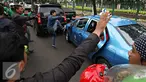 Pengendara ojek online merusak dan melakukan sweeping di kawasan Senayan, Jakarta, Selasa (22/3). Pascabentrok ojek online melakukan sweeping dan perusakan terhadap taksi serta bajaj yang melintas di kawasan tersebut. (Liputan6.com/Immanuel Antonius)