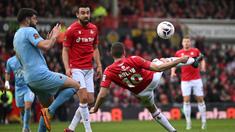 Pemain Wrexham, Paul Mullin (kanan) berusaha menjebol gawang Boreham Wood dalam pertandingan English National League yang berlangsung di The Racecourse Ground, Wales, Sabtu (22/4/2023) WIB. Paul Mullin mencetak brace dalam kemenangan 3-1 yang diraih Wrexham. (AFP/Oli Scarff)