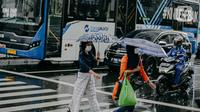 Pejalan kaki menggunakan payung saat hujan deras mengguyur kawasan Jalan Thamrin, Jakarta, Selasa (31/5/2022). Potensi cuaca ekstrem di sejumlah wilayah di Indonesia pada hari ini dipengaruhi oleh kemunculan bibit siklon tropis 92S di Samudera Hindia selatan Jawa Barat. (Liputan6.com/Faizal Fanani)