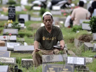 Warga memanjatkan doa saat berziarah ke makam kerabat di Taman Pemakaman Umum (TPU) Kemiri, Rawamangun, Jakarta, Minggu (23/4/2023). (merdeka.com/Iqbal S. Nugroho)