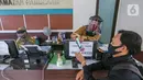 Petugas loket lengkap dengan masker dan face shield melayani warga saat proses pembuatan KTP Elektronik di Kecamatan Pamulang, Tangerang Selatan, Senin (15/6/2020). Dukcapil Tangsel membuka layanan rekaman E-KTP jelang Pilkada dengan menerapkan ketentuan New Normal. (Liputan6.com/Fery Pradolo)