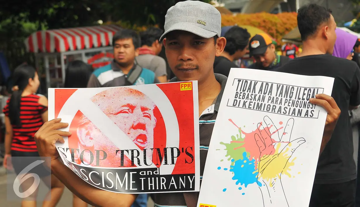 Seorang pria dari front Perjuangan Rakyat menunjukan poster saat melakukan aksi di Jakarta, Minggu (5/2). Aksi tersebut untuk menolak kebijakan Trump atas keputusannya melarang masuknya warga muslim di 7 negara selama 90 hari. (Liputan6.com/Angga Yuniar)