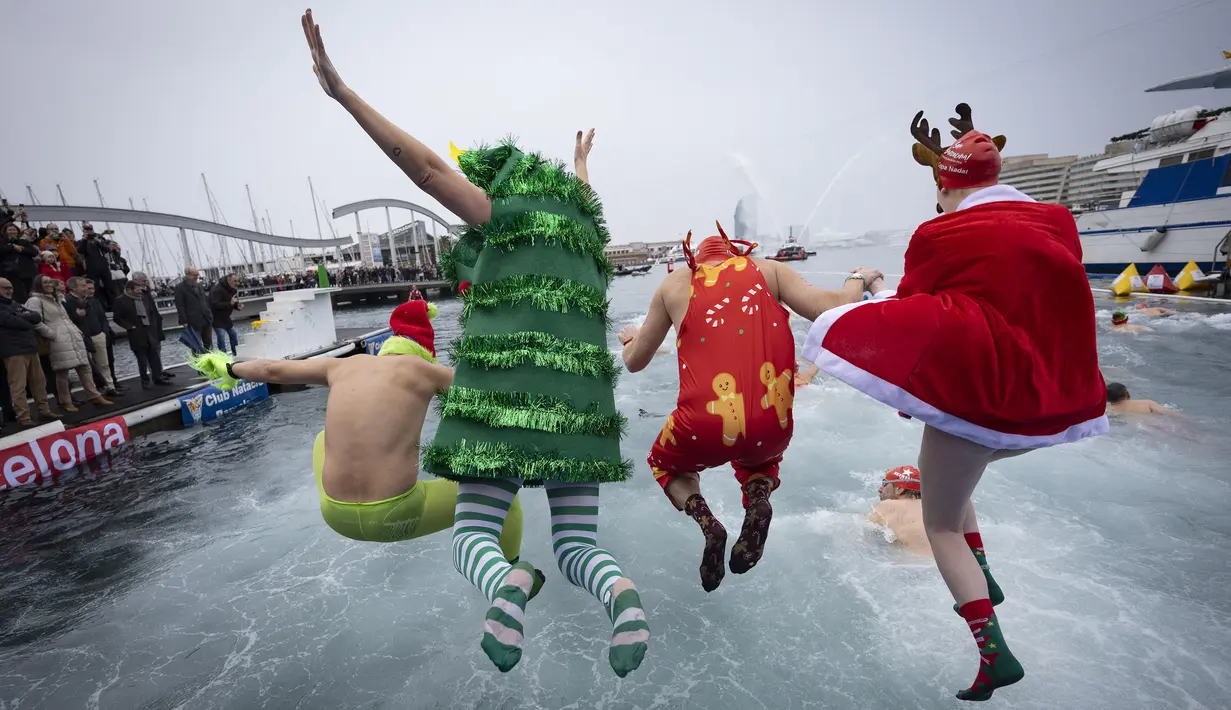 Sejumlah peserta berkostum khas hari Natal melompat ke dalam air dalam ajang Copa Nadal yang berlangsung di Barcelona's Port Vell, Barcelona, Kamis (25/12/2025) waktu setempat. Acara tersebut diikuti lebih dari 450 peserta. (AFP/Josep Lago)