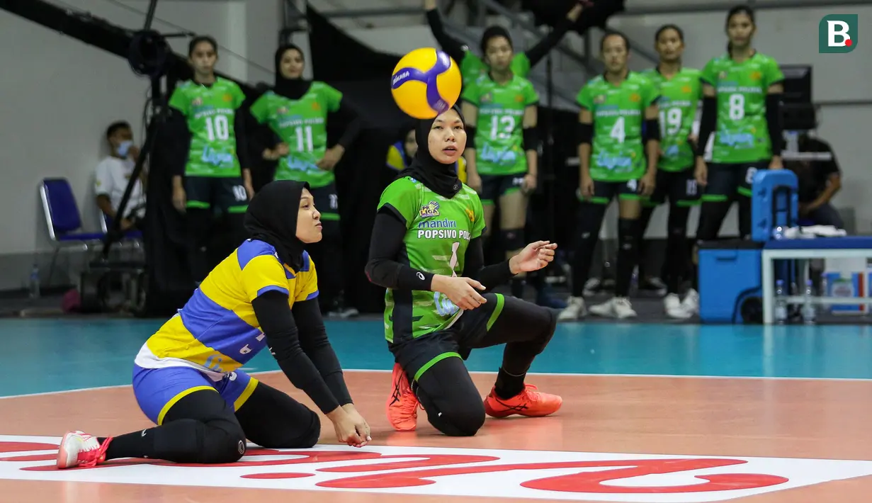 Pemain Jakarta Mandiri Popsivo Polwan, Eris Wulandari (kiri) dan Fajriahni Ema Herawati berusaha mengembalikan bola saat perebutan tempat ketiga grand final PLN Mobile Proliga 2022 melawan Jakarta Pertamina Fastron di Padepokan Bola Voli Sentul, Sabtu (26/03/2022). (Bola.com/Bagaskara Lazuardi)