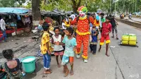 Dengan bantuan alat peraga dan poster, pria India ini dengan sabar menunjukkan kepada mereka cara mencuci tangan dan memakai masker dengan benar (AFP)