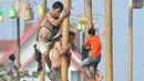 Sejumlah warga berebut memanjat pada lomba Panjat Pinang Kolosal dalam rangka merayakan HUT RI ke-70 di Pantai Karnaval, Ancol, Jakarta, Senin (17/8). Sebanyak 124 batang pinang disediakan dengan berbagai ragam hadiah. (Liputan6.com/Herman Zakharia)