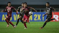 Pemain Persis Solo, Irfan Bachdim (tengah) berusaha melewati pemain Rans Cilegon FC, Muhammad Fadila Akbar (kanan) dalam laga final Liga 2 2021 di Stadion Pakansari, Bogor, Kamis (30/12/2021). (Bola.com/Bagaskara Lazuardi)