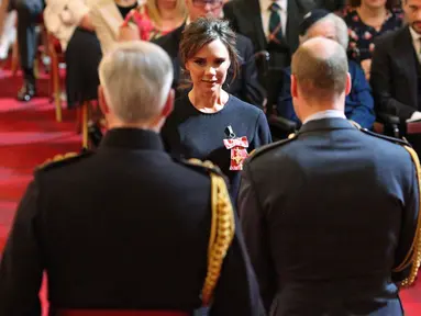 Desainer Victoria Beckham saat menerima gelar Order of the British Empire (OBE) dari Pangeran William di Istana Buckingham, London (19/4). Ibu 4 anak ini mendapatkan gelar kehormatan di bidang fashion selama 17 tahun.  (Yui Mok / PA via AP)