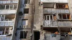 Otoritas setempat pada Rabu 31 Desember 2025 mengatakan, serangan tersebut merusak bangunan tempat tinggal dan infrastruktur. Tampak dalam foto, warga berdiri di balkon sebuah bangunan tempat tinggal yang rusak akibat serangan di Odesa, pada 31 Desember 2025, di tengah invasi Rusia di Ukraina. (Oleksandr GIMANOV/AFP)