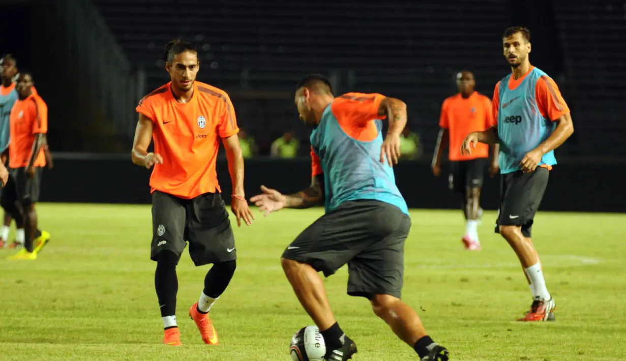 Pemain belakang Juventus, Martín Cáceres (kiri), mencoba menahan laju rekan setimnya saat berlatih di Stadion GBK Jakarta, (5/8/2014), jelang berlaga melawan ISL All Stars. (Liputan6.com/Helmi Fithriansyah)