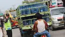Petugas polisi mengatur lalu lintas di pasar Tumpah Bangkir Indramayu, Jawa Barat, Jumat (30/6). Pasar Tumpah Bangkir yang di padati pengunjung di H+5 libur lebaran menyebabkan kemacetan arus lalu lintas ke Arah Jakarta. (Liputan6.com/Helm Afandi)