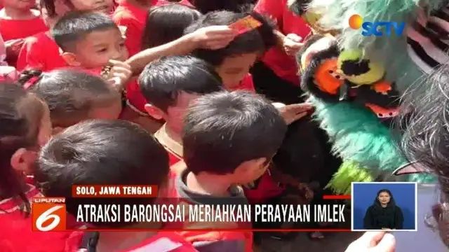 Atraksi barongsai di Solo, Jawa Tengah, pukau ratusan siswa SD yang tengah menyaksikan. Para siswa tersebut pun antusias berebut memasukkan angpau ke dalam mulut barongsai.