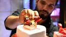Pembuat kue memberikan sentuhan akhir pada sebuah kue berbentuk hati pada momen Hari Valentine di Damaskus, Suriah, Rabu (12/2/2020). (Xinhua/Ammar Safarjalani)