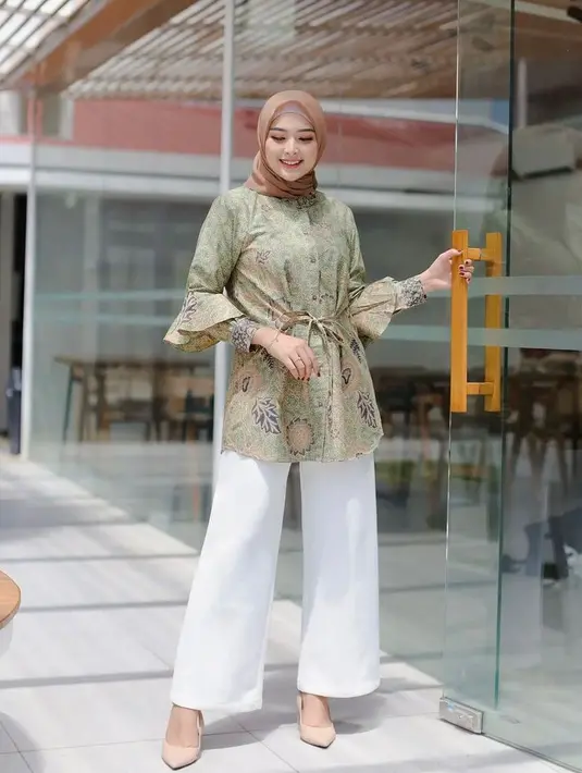 Blouse batik dengan detail tali di bagian depan dan ruffle di bagian lengan juga tak kalah menarik untuk kamu coba sebagai outfit ke kantor. (Instagram/jumputan_inten).
