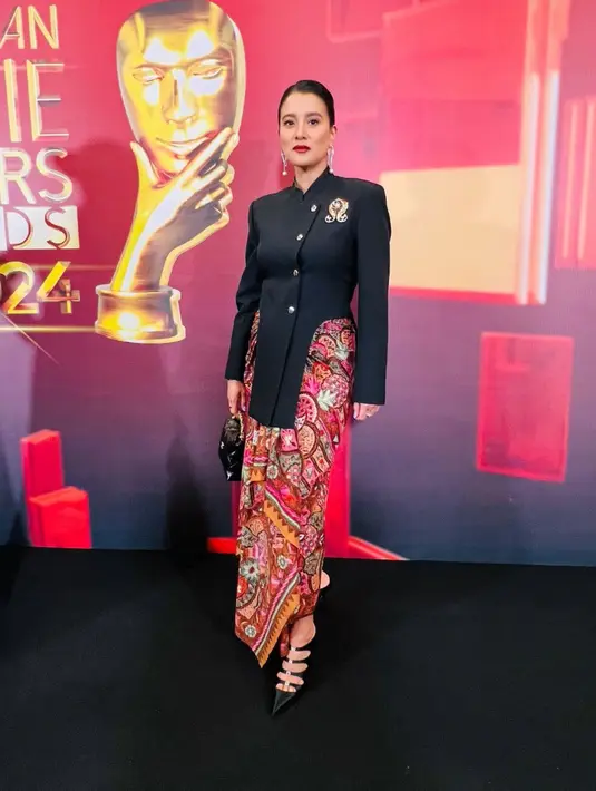 Marcella Zalianty hadir mengenakan kebaya janggan modifikasi warna dengan aksen bros keemasan dipadukan bawahan kain batik colorfull. Busana dari Wilsen Willim dipadukan heels berstrap hitam dan handbag hitamnya. [@marcella.zalianty]