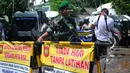 Seorang TNI tampak berjaga di sekitar pintu masuk dermaga Lapas Nusakambangan, Cilacap, Senin (27/4). Menjelang eksekusi mati terpidana narkoba, sterilisasi diberlakukan terhadap seluruh akses penyebrangan ke Nusakambangan. (Liputan6.com/Yoppy Renato)