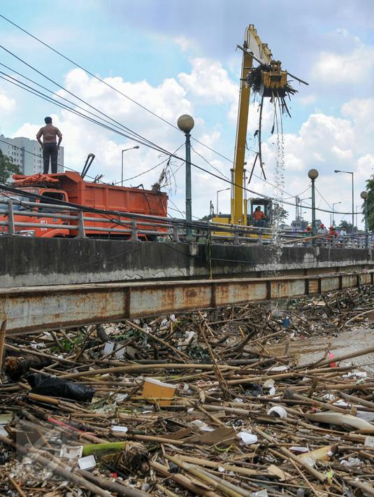 Petugas Sudin Kebersihan DKI Jakarta menurunkan alat berat untuk mengangkut sampah yang menumpuk di jembatan Kampung Melayu, Jatinegara, Jakarta Timur, Minggu (3/4/2016). (Liputan6.com/Yoppy Renato)