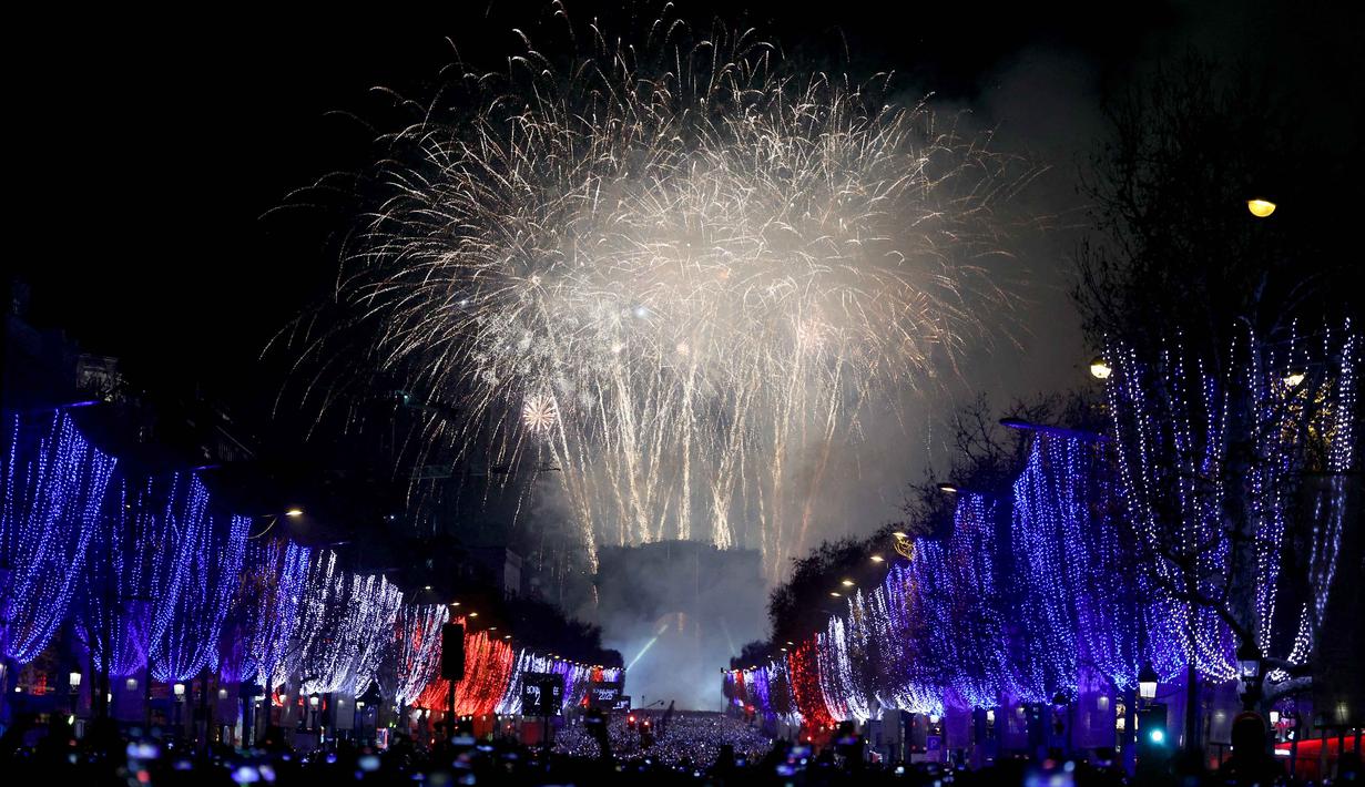 Kembang api meledak di langit di atas Arc de Triomphe, di Place de l'Etoile, Paris, untuk merayakan Tahun Baru, tepat setelah tengah malam pada 1 Januari 2026. (Alain JOCARD/AFP)