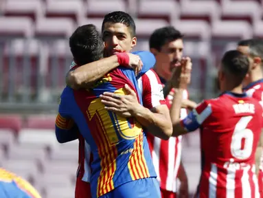 Striker Atletico Madrid, Luis Suarez, berpelukan dengan striker Barcelona, Lionel Messi, pada laga Liga Spanyol di Stadion Camp Nou, Sabtu (8/5/2021). Kedua tim bermain imbang 0-0. (APJoan Monfort)