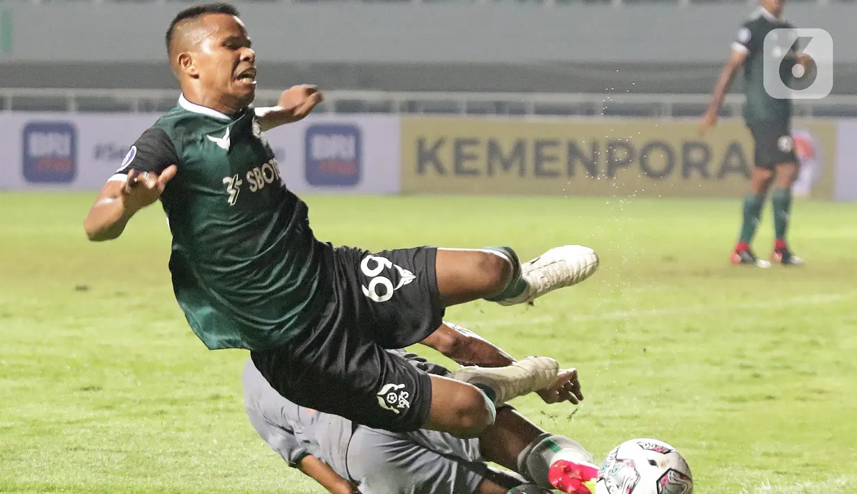 Kapten tim Persikabo 1973, Manahati Lestusen (kir) saat berebut bola dengan pemain Persebaya Surabaya pada lanjutan pekan pertama BRI Liga 1 Indonesia 2022-2023 di Stadion Pakansari, Kabupaten Bogor, Senin (25/7/2022). Persikabo 1973 unggul atas Persebaya Surabaya lewat gol dari titik penalti yang dicetak Gustavo Tocantins. (Liputan6.com/Helmi Fithriansyah)