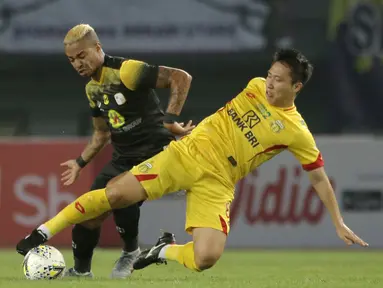 Gelandang Bhayangkara FC, Lee Yoo-joon, berebut bola dengan bek Barito Putera, Ronny Beroperay, pada laga Liga 1 2019 di Stadion Patriot, Bekasi, Selasa (29/5). Bhayangkara menang 4-2 atas Barito. (Bola.com/Yoppy Renato)