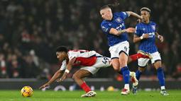 Pemain Arsenal, Myles Lewis-Skelly (kiri) berebut bola dengan pemain Ipswich Town, Kalvin Phillips pada laga lanjutan Liga Inggris 2024/2025 di Emirates Stadium, London, Inggris, Sabtu (28/12/2024) WIB. (AFP/Glyn Kirk)