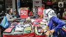 Para pengunjung melihat pakaian yang dijajakan di salah satu tenant di Pasar Baru, Jakarta, Rabu (5/4/2021). Selama pandemi COVID-19, tak banyak orang yang mau berbelanja di luar rumah. (Liputan6.com/Faizal Fanani)