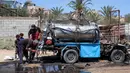 Dikabarkan pada Minggu (13/7/2025), sebanyak 10 warga Gaza, termasuk 6 di antaranya anak-anak meninggal dunia akibat serangan udara saat mengambil air di titik distribusi di kamp pengungsi Nuseirat. (Eyad BABA/AFP)
