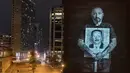 Tokoh TV Uruguay Diego Gonzalez memegang gambar Carlos Arevalo, yang menghilang selama kediktatoran militer (1973-1985), diproyeksikan di dinding gedung dalam rangka Peringatan March of Silence, saat pembatasan COVID-19, diadakan secara virtual di Montevideo, 20 Mei 2020. (Pablo PORCIUNCULA/AFP)