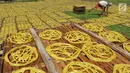 Pekerja menjejerkan kerupuk mie kuning untuk dijemur sebelumnya dijual ke konsumen di Karadenan, Bogor (22/05). Tahun sebelumnya para pedagang menjual Rp 50 ribu/4 kilogram. (Merdeka.com/Arie Basuki)