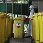 Petugas membawa "Wheeled Bin" atau tempat sampah berisi limbah B3 medis Infeksius Covid-19 untuk dimusnahkan di PT Jasa Medivest, Karawang, Jawa Barat, Kamis (10/12/2020).  PT Jasa Medivest telah memusnahkan lebih dari 500 ton limbah B3 medis dari Maret - Oktober 2020. (Liputan6.com/Herman Zakharia)