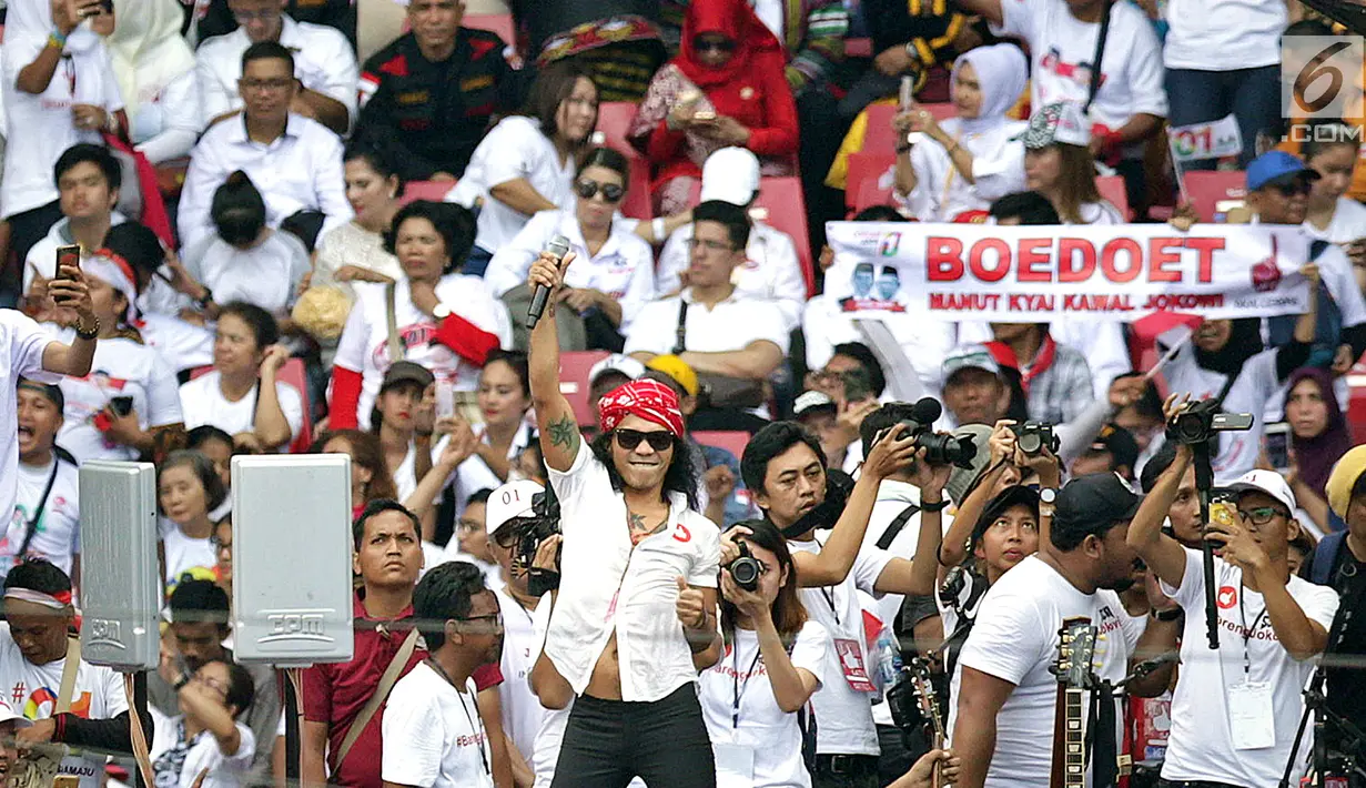 Vokalis grup band SLANK, Kaka tampil membawakan lagu dalam pagelaran Konser Putih Bersatu di Stadion GBK, Senayan, Jakarta, Sabtu (13/4). SLANK membuka penampilan dengan lagu berjudul Mars Slankers, Kuil Cinta dan Lo Harus Gerak. (Fimela.com/Bambang Eros)