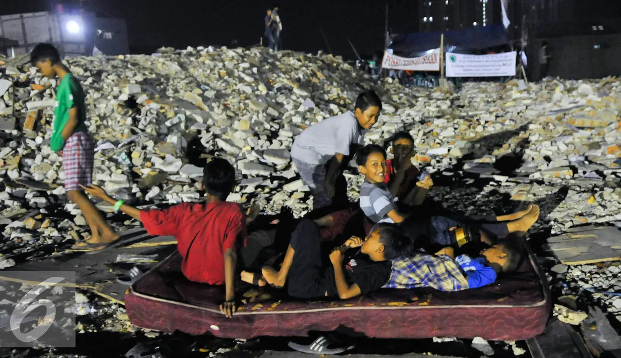 Sejumlah anak belajar bermain di tempat gusuran Pasar Ikan, Jakarta, Jumat (29/4/2016). Warga memilih bertahan di perahu atau tenda daripada pindah ke rusun. (Liputan6.com/Yoppy Renato)