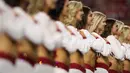 Cheerleaders dari tim Arizona Cardinals mendengarkan lagu kebangsaan sebelum pertandingan NFL melawan Oakland Raiders di University of Phoenix Stadium di Glendale, Arizona (12/8). (Christian Petersen / Getty Images / AFP)
