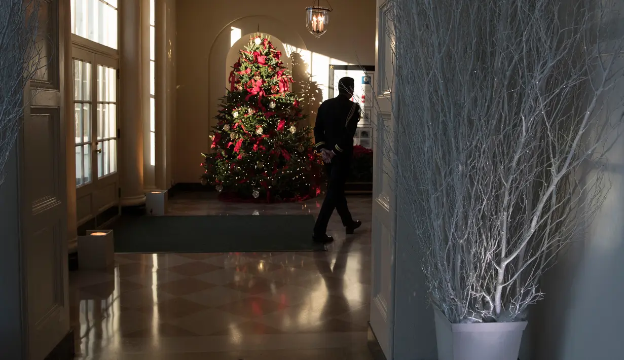 Pohon Natal terlihat di ruang East Gardner Gedung Putih, Senin (27/11). First Lady Melania Trump mendekorasi perayaan Natal dengan tema 'Time-Honored Traditions' yang mencerminkan tradisi liburan 200 tahun di Gedung Putih. (AP Photo/Carolyn Kaster)
