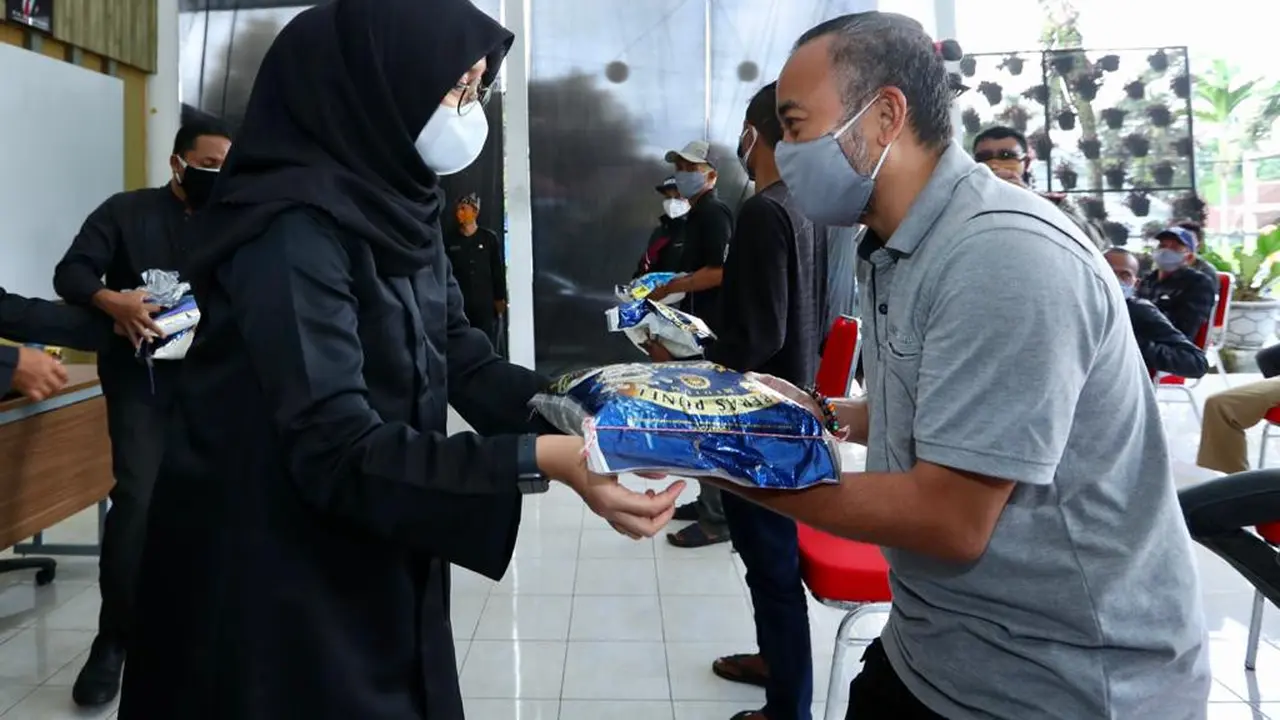 Bupati Banyuwangi Ipuk Fiestiandani membagikan sembako ke pelaku wisata Ijen. (Dian Kurniawan/Liputan6.com)