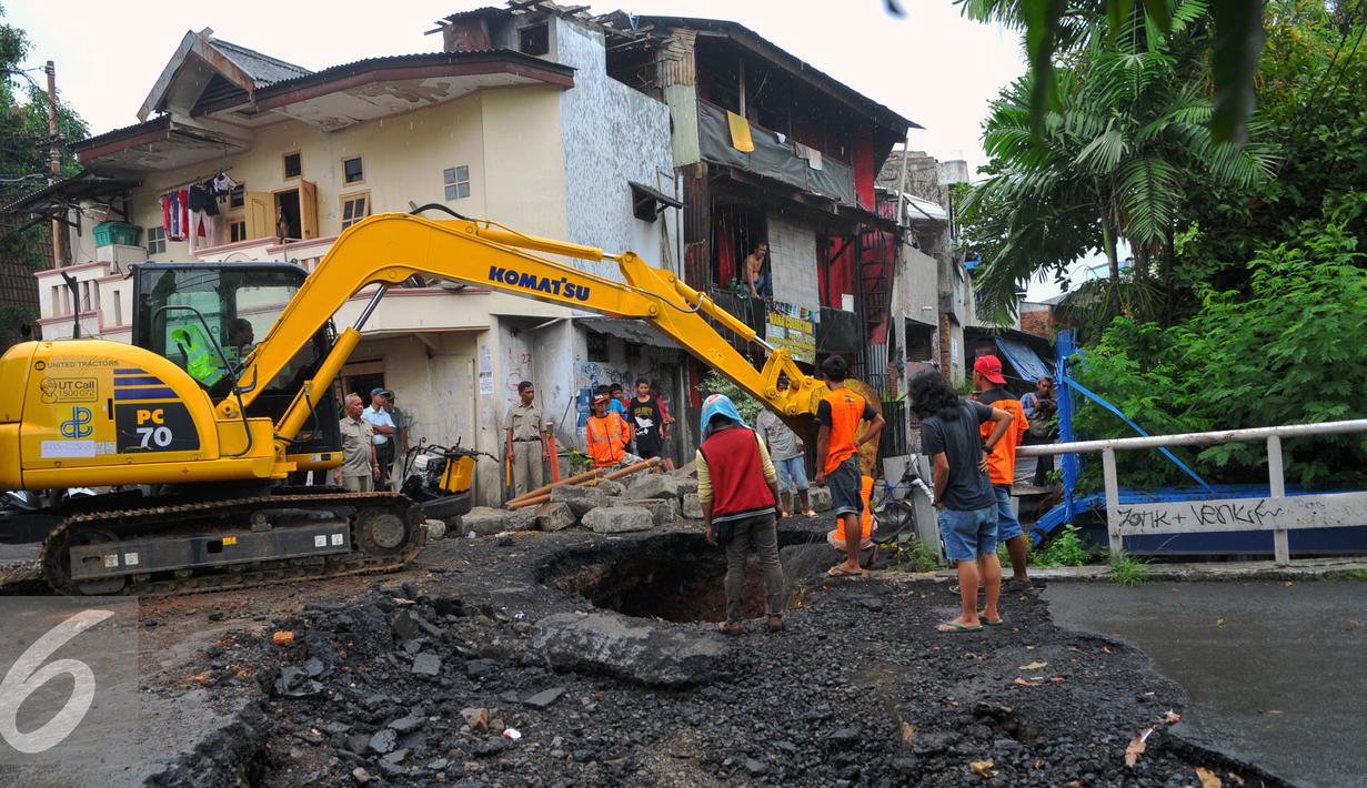 Petugas Dinas PU melakukan perbaikan Jembatan Inspeksi Kali Grogol yang ambles di Komplek Hankam, Slipi, Jakarta, Senin (21/3). Penyebab Amblesnya jembatan diduga terjadi pergeseran tanah dibagian pondasi jembatan. (Liputan6.com/Faisal R Syam)
