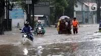 Pengendara sepeda motor menerjang banjir yang menggenangi kawasan Jalan Wolter Monginsidi Jakarta dan sekitarnya, Sabtu (20/2/2021). Hujan yang mengguyur Jakarta sejak Jumat (19/2) membuat sejumlah titik di Jakarta terendam banjir. (Liputan6.com/Helmi Fithriansyah)