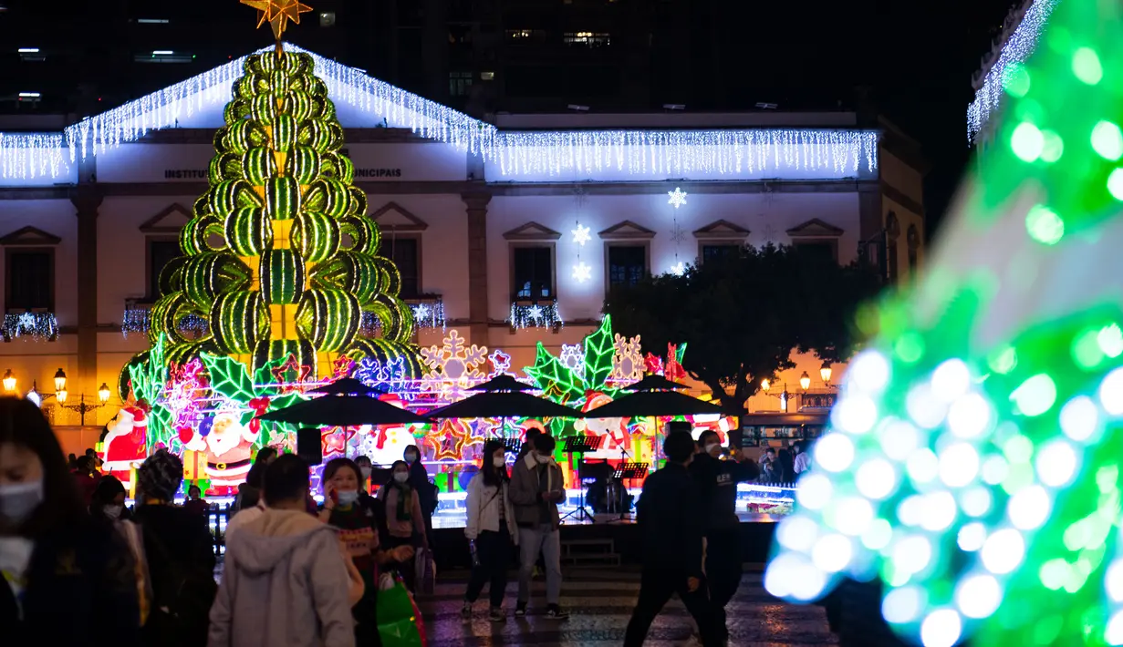 Para wisatawan menyaksikan dekorasi Natal di Largo Do Senado, Makau, China, 22 Desember 2020. Largo do Senado atau Senado Square merupakan area perbelanjaan yang terkenal di Makau. (Xinhua/Cheong Kam Ka)