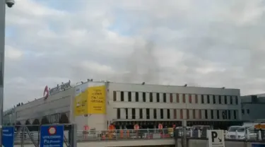 Asap hitam terlihat mengepul dari bandara Zaventem di Brussel, setelah terjadi ledakan, Belgia, Selasa (22/3). Sedikitnya 13 orang tewas akibat dua ledakan beruntun yang mengguncang ruang keberangkatan bandara tersebut. (REUTERS/Peter van Rossum)